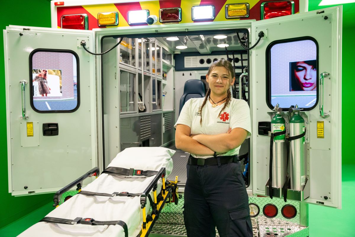 paramedicine student in front on an ambulance