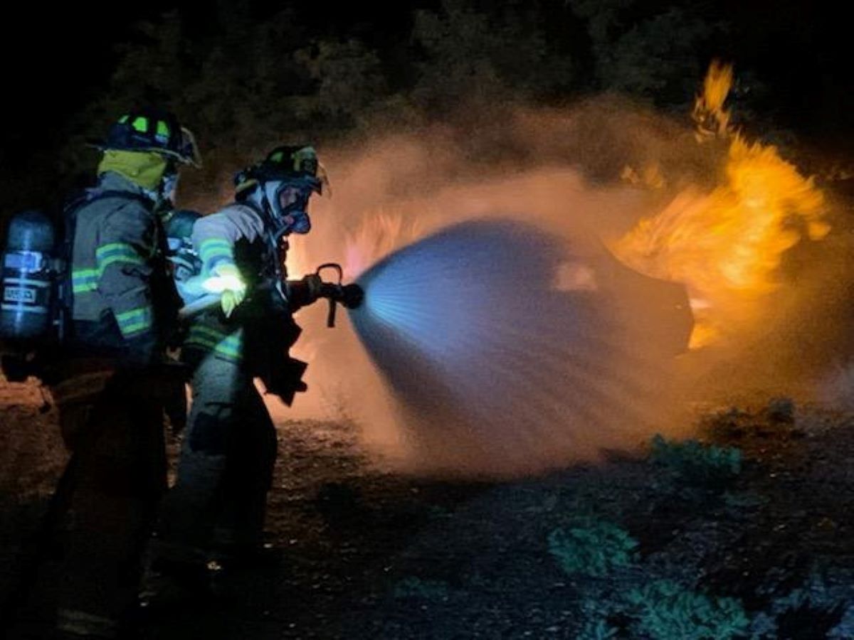 firefighters using a hose