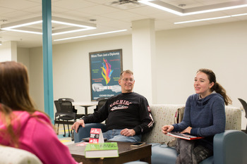 Three students visiting with each other at the Downtown Center