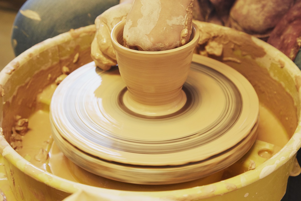 Student using a potter's wheel in ceramics