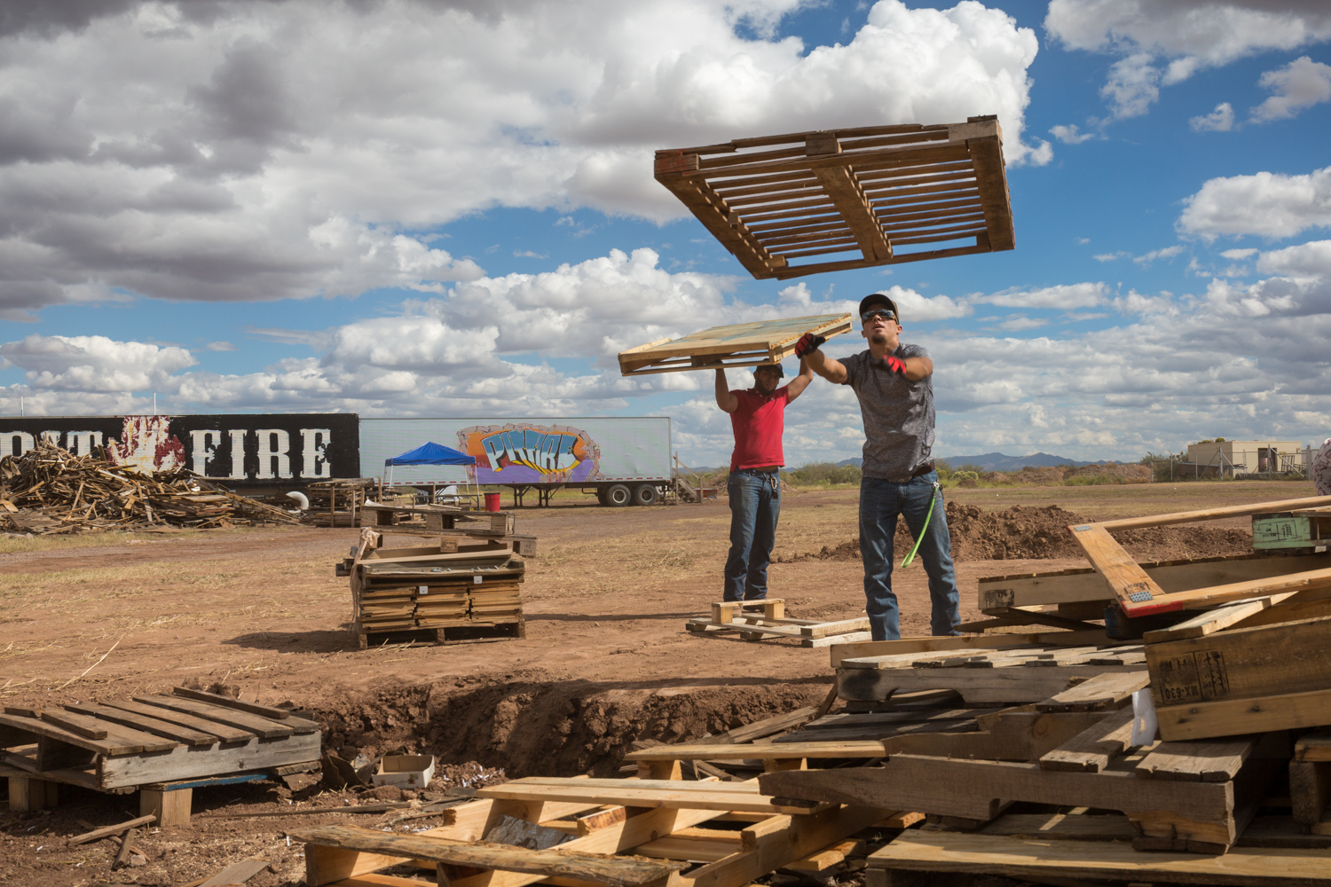 Volunteers stacking wood above the pit