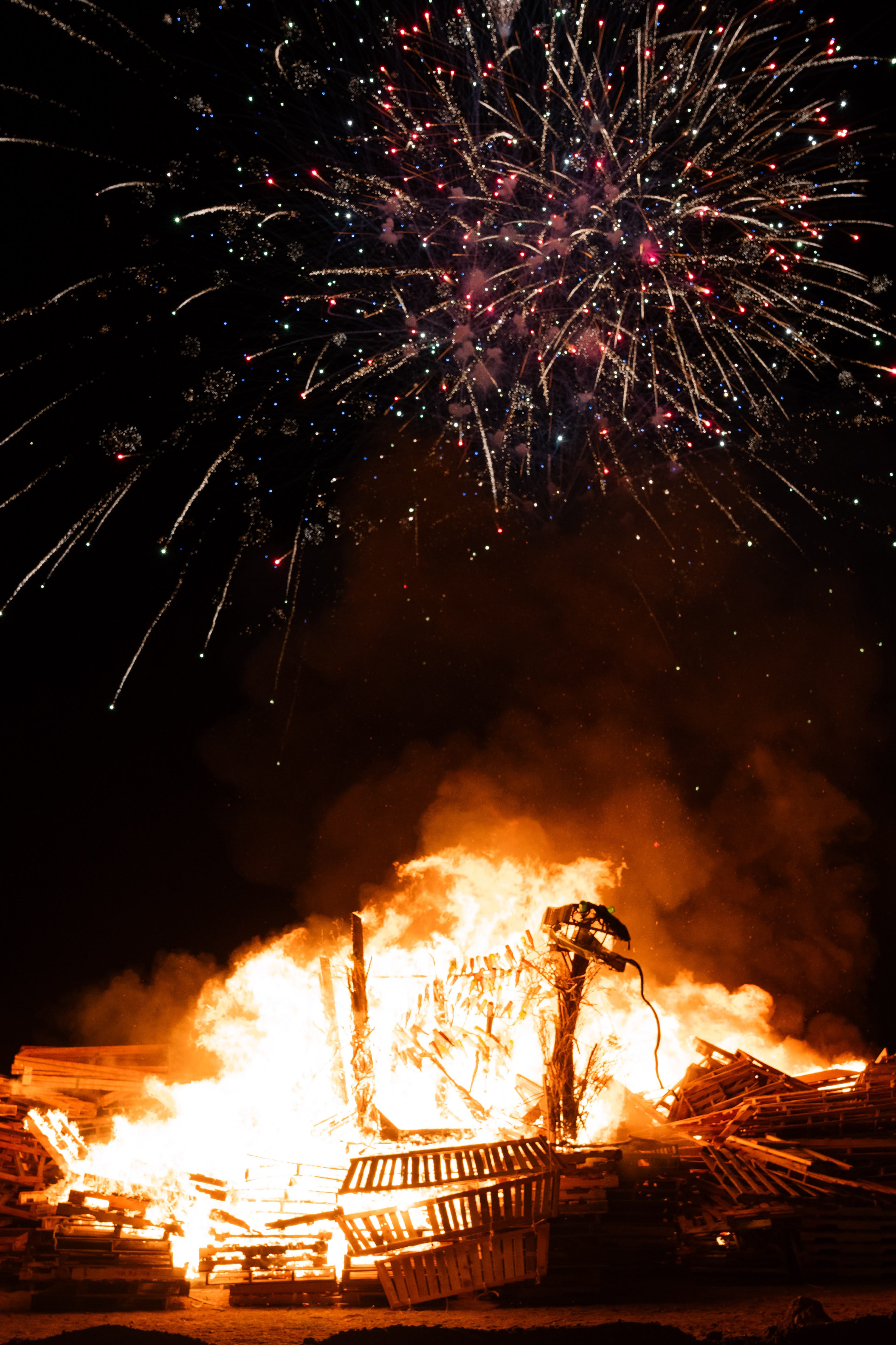 Pit on fire with fireworks going off above