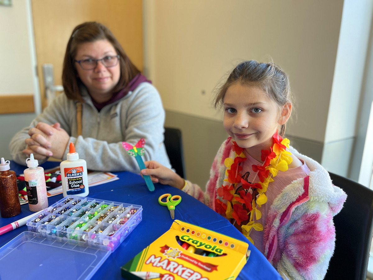 Child and instructor using beads for an art project